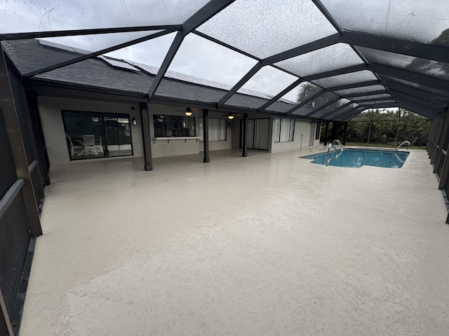 view of swimming pool with a patio and glass enclosure