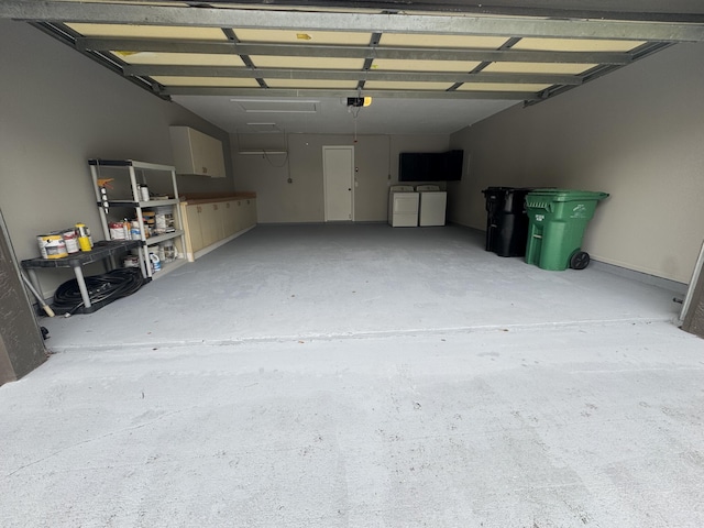 garage featuring a garage door opener and separate washer and dryer