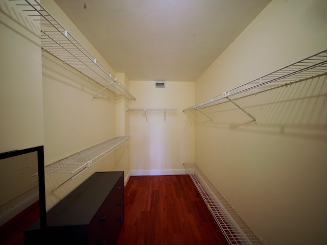 walk in closet with dark wood finished floors and visible vents