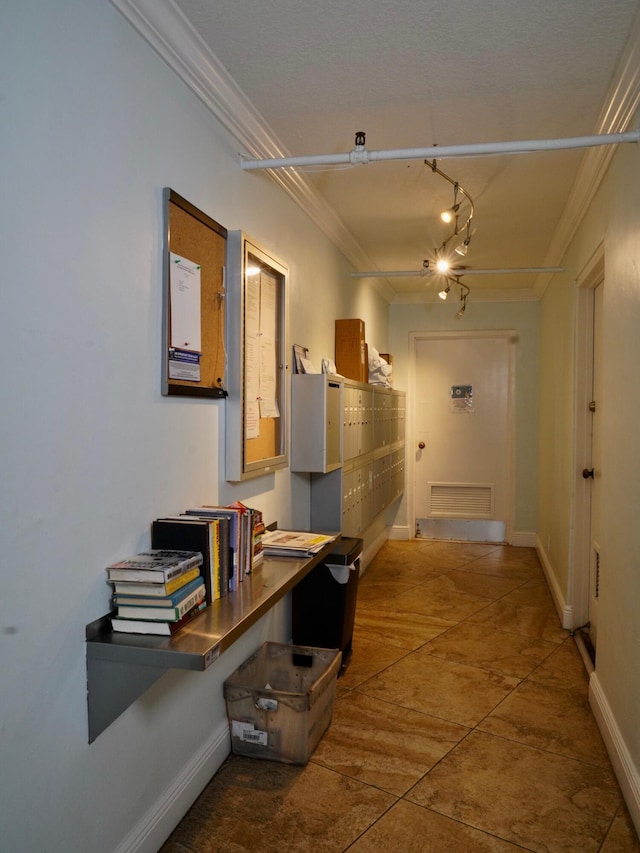 hall with rail lighting, visible vents, baseboards, and crown molding