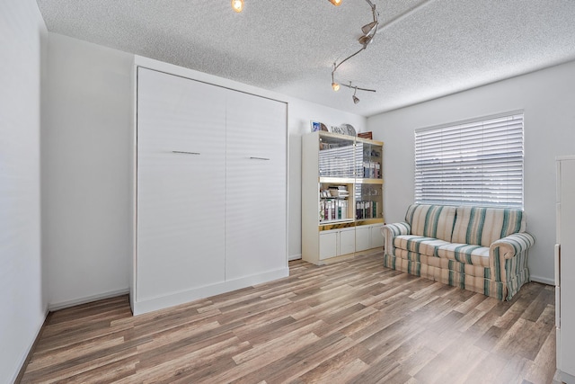 living area with hardwood / wood-style flooring and a textured ceiling