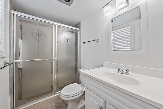 bathroom with a shower with door, toilet, and vanity