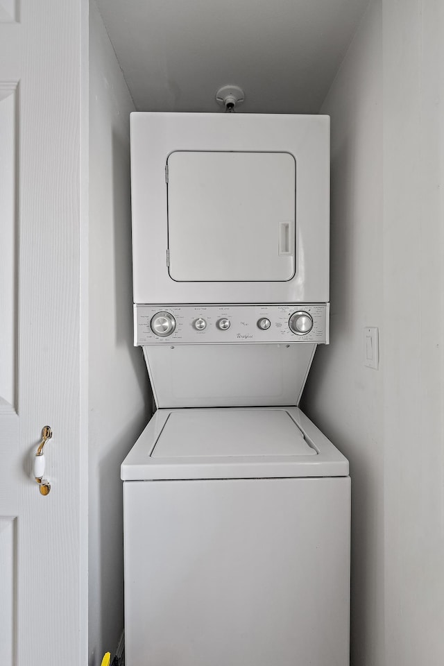 laundry room featuring stacked washer / drying machine