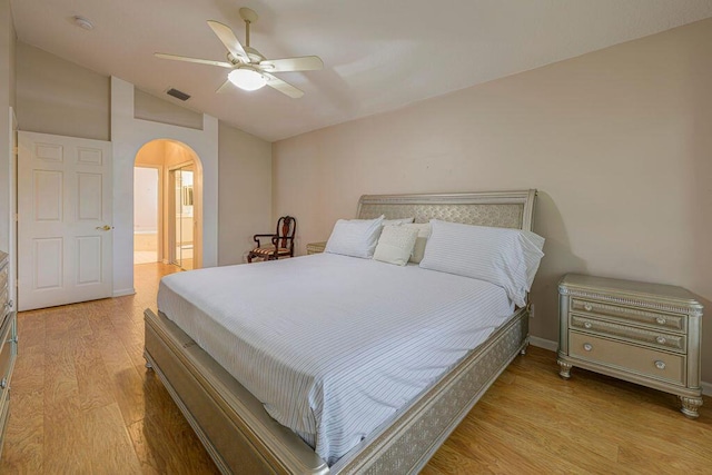 bedroom featuring vaulted ceiling, ensuite bath, ceiling fan, and light hardwood / wood-style floors