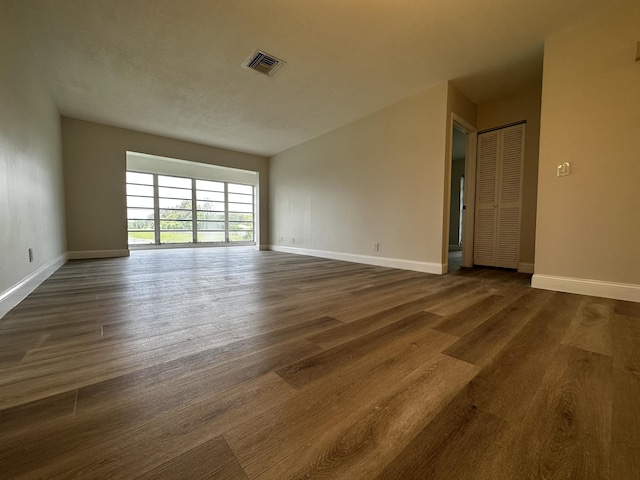 spare room featuring dark wood-type flooring