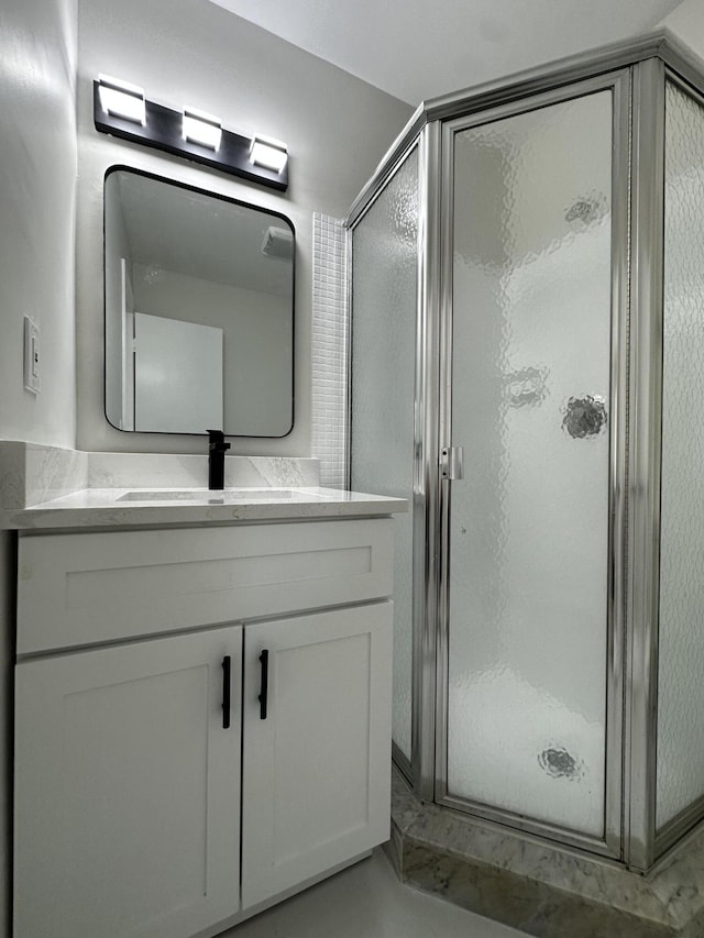 bathroom with walk in shower and vanity