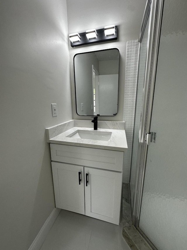 bathroom featuring a shower with door, vanity, and tile patterned flooring