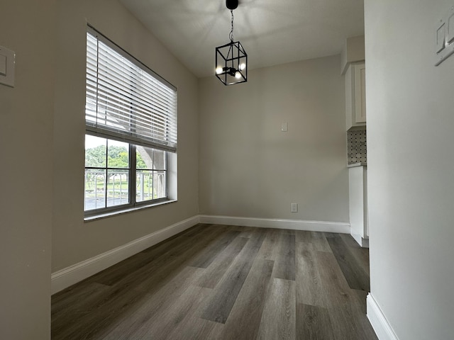 unfurnished dining area featuring dark hardwood / wood-style floors and a notable chandelier