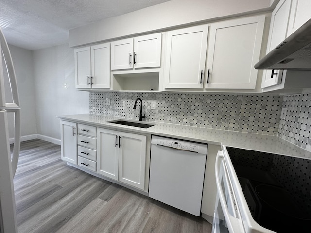 kitchen with white appliances, white cabinets, a textured ceiling, light hardwood / wood-style flooring, and sink