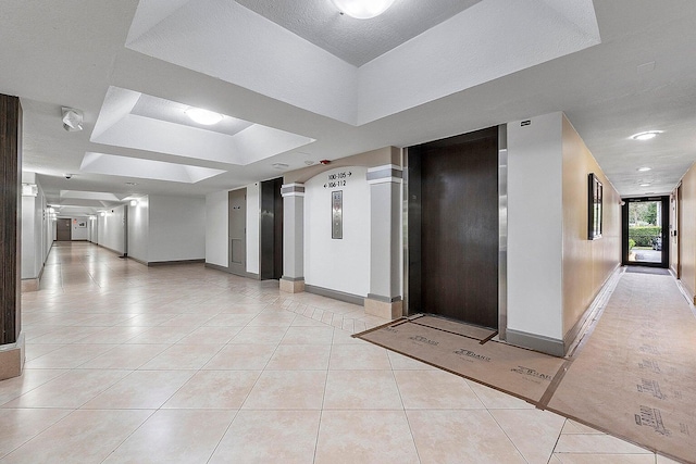 kitchen with a tray ceiling and light tile patterned flooring