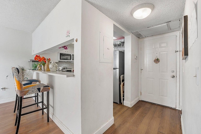 hall with hardwood / wood-style flooring and a textured ceiling