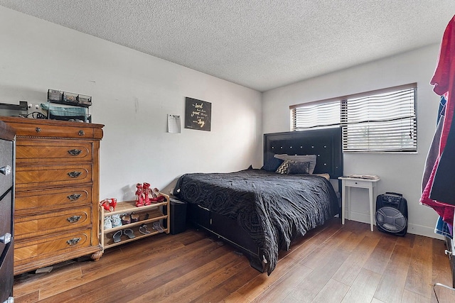 bedroom featuring dark wood-type flooring and a textured ceiling