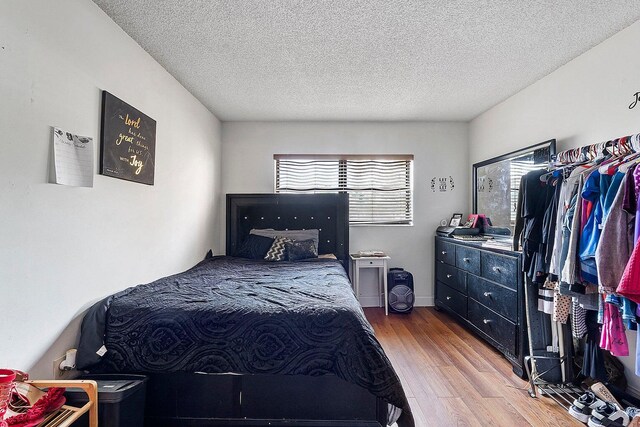 bedroom featuring hardwood / wood-style flooring and a textured ceiling