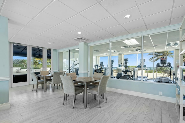 dining room featuring french doors, a drop ceiling, and floor to ceiling windows