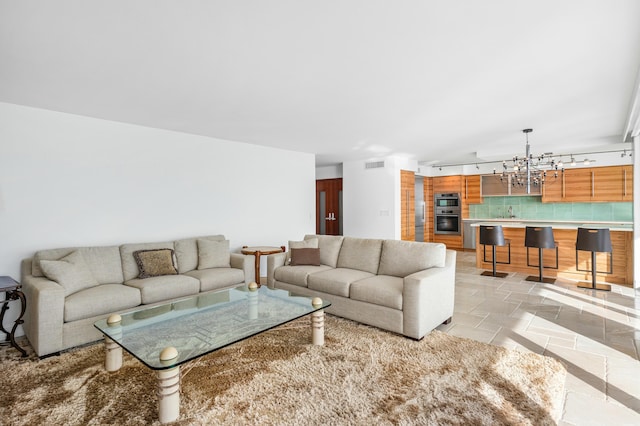 tiled living room featuring an inviting chandelier