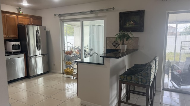 kitchen featuring light tile patterned flooring, stainless steel appliances, and a wealth of natural light