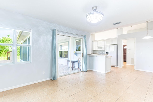 interior space with white cabinetry, light tile patterned floors, white appliances, and decorative light fixtures