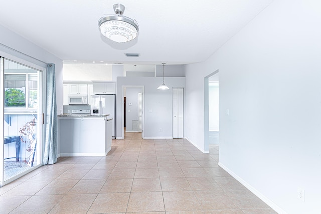 interior space featuring white cabinetry, hanging light fixtures, white appliances, and light tile patterned floors