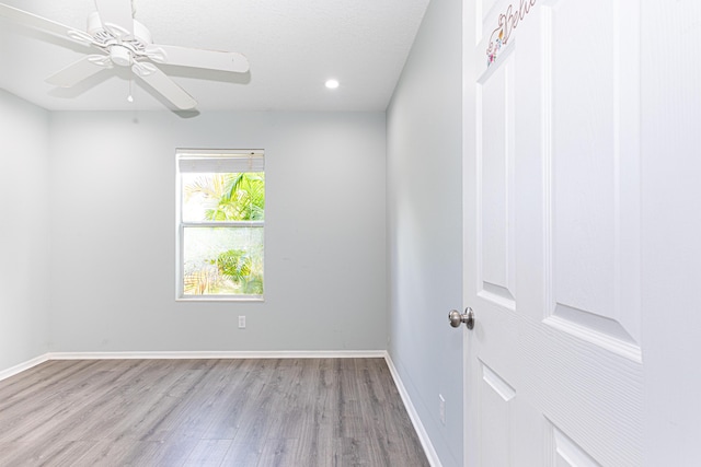 empty room featuring a textured ceiling, light hardwood / wood-style flooring, and ceiling fan