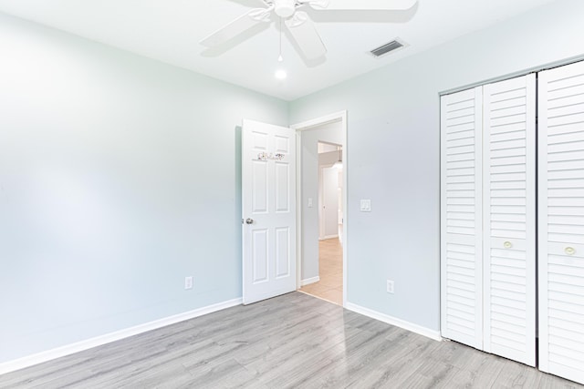 unfurnished bedroom with ceiling fan, light hardwood / wood-style floors, and a closet