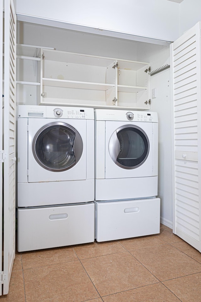 washroom featuring light tile patterned floors and washer and clothes dryer