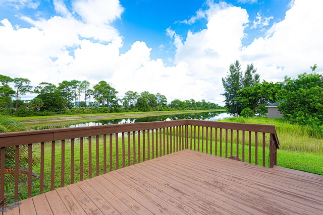 wooden terrace with a yard and a water view