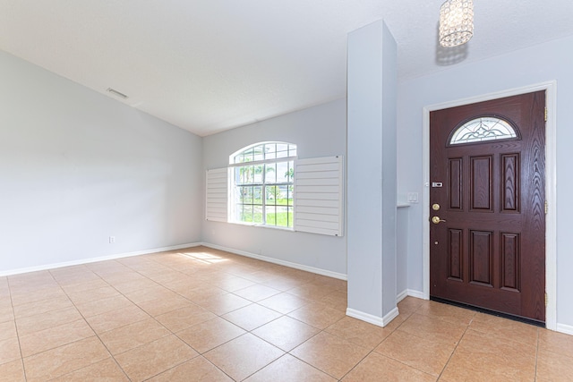 foyer with a textured ceiling and light tile patterned floors