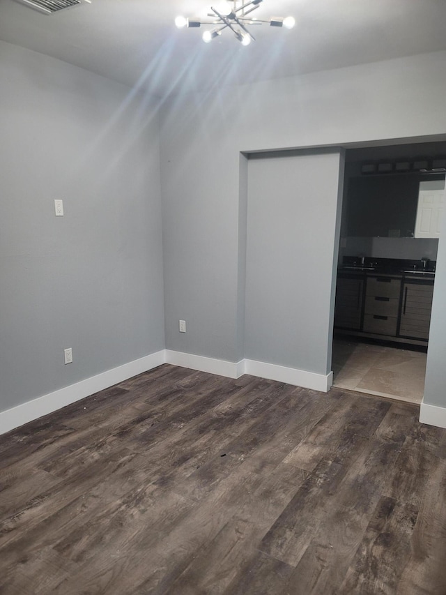 interior space with dark wood-type flooring, sink, and an inviting chandelier