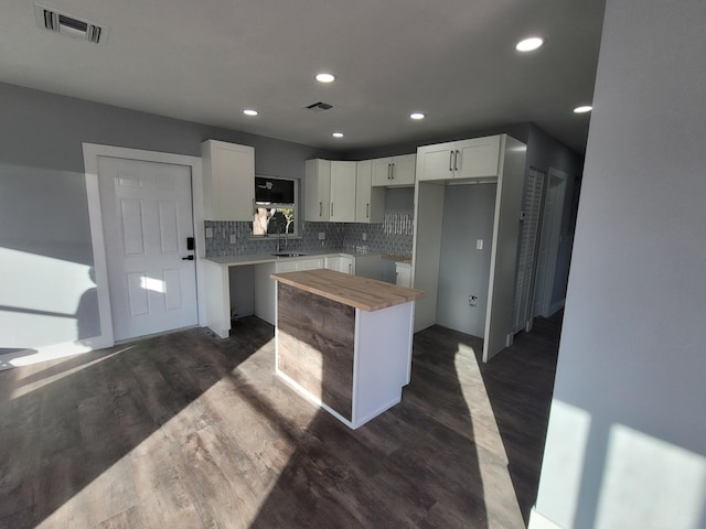 kitchen featuring tasteful backsplash, butcher block counters, white cabinets, and dark hardwood / wood-style flooring