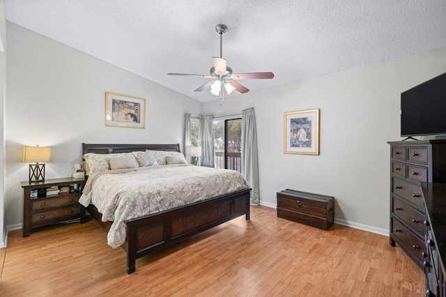 bedroom with ceiling fan, a textured ceiling, vaulted ceiling, and light wood-type flooring