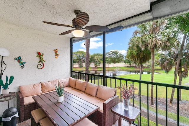 sunroom / solarium with ceiling fan and a water view