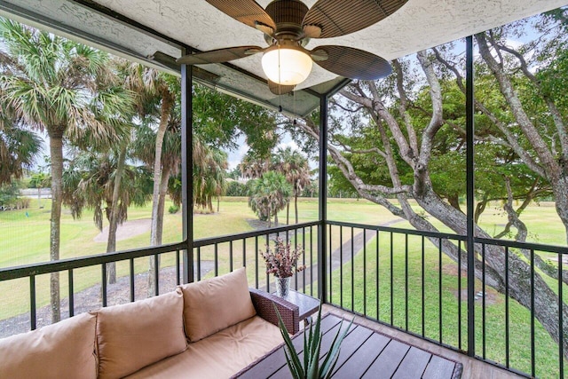 unfurnished sunroom featuring ceiling fan