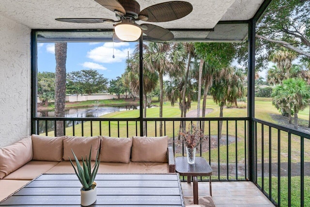 sunroom with a water view and ceiling fan