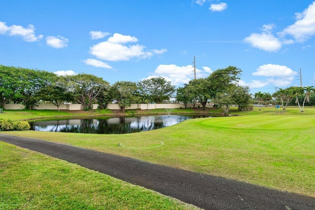 view of home's community with a water view and a lawn