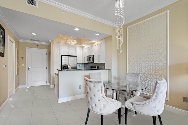 tiled dining space featuring a chandelier and ornamental molding