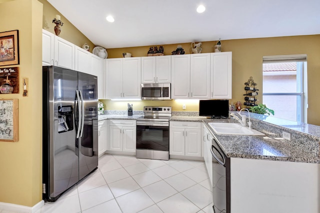 kitchen featuring appliances with stainless steel finishes, white cabinetry, light tile patterned floors, sink, and stone countertops