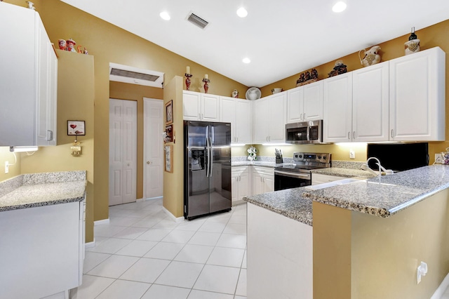 kitchen with white cabinetry, appliances with stainless steel finishes, kitchen peninsula, and lofted ceiling