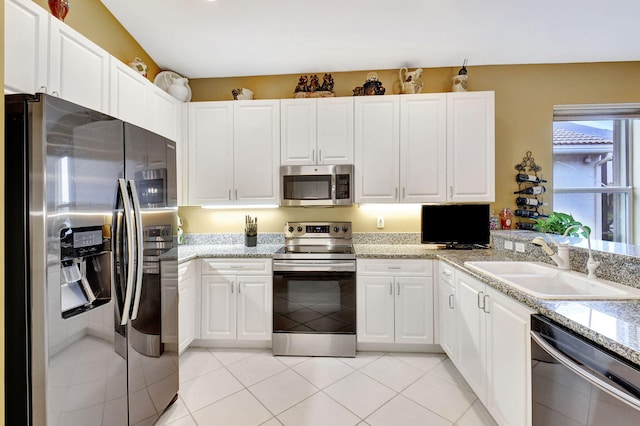 kitchen with sink, white cabinetry, light tile patterned floors, and stainless steel appliances