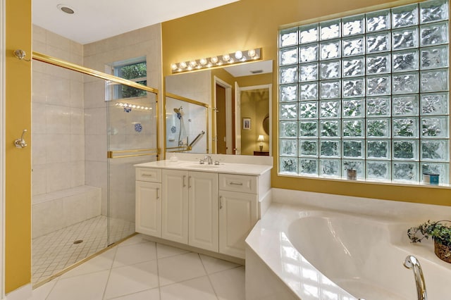 bathroom featuring independent shower and bath, vanity, and tile patterned flooring