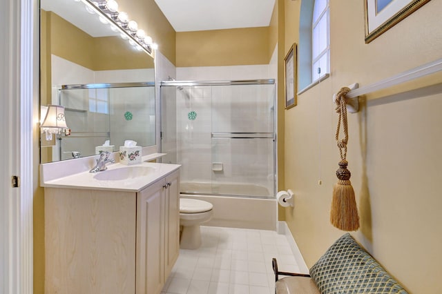 full bathroom featuring vanity, toilet, bath / shower combo with glass door, and tile patterned flooring