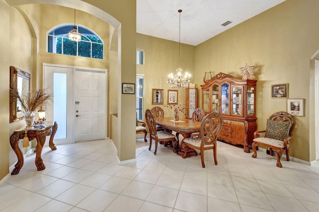 tiled entrance foyer featuring a high ceiling, an inviting chandelier, and a healthy amount of sunlight