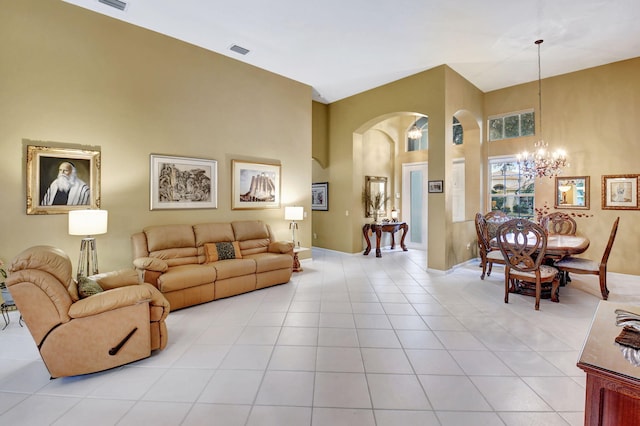 tiled living room featuring an inviting chandelier