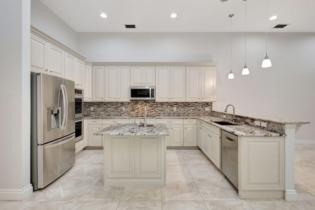 kitchen with stainless steel appliances, an island with sink, hanging light fixtures, and sink