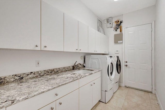 clothes washing area featuring cabinets, sink, light tile patterned floors, and independent washer and dryer