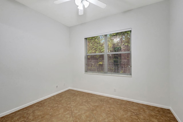 empty room featuring ceiling fan and tile patterned flooring