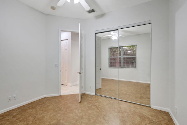 unfurnished bedroom with ceiling fan, light tile patterned floors, and a closet