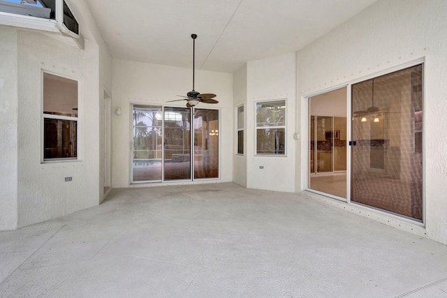 unfurnished sunroom featuring ceiling fan