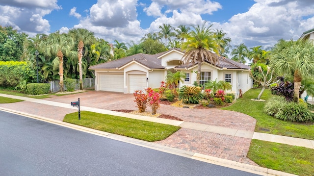 mediterranean / spanish-style home with a front lawn and a garage