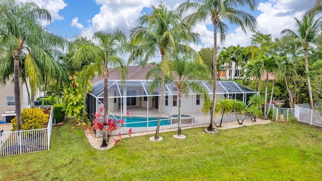 rear view of property featuring a fenced in pool, glass enclosure, a patio area, and a lawn