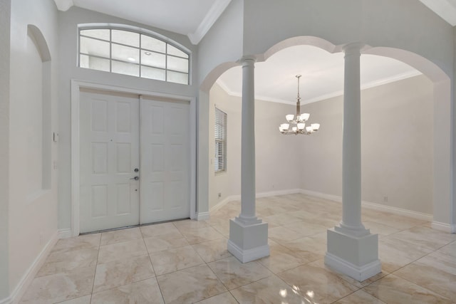 foyer entrance with a notable chandelier, ornamental molding, high vaulted ceiling, and decorative columns